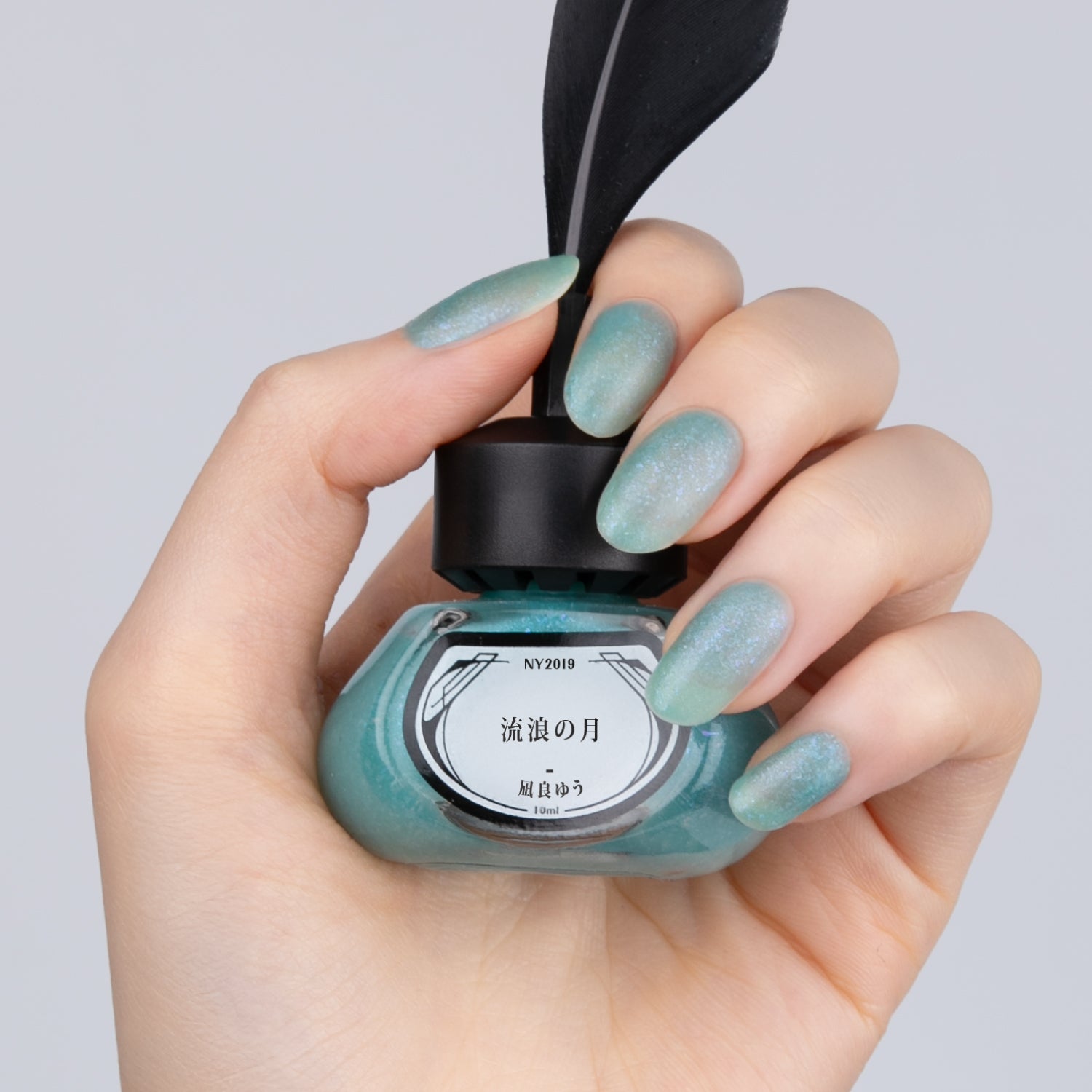 NY2019 流浪の月【8/25正午発売】 - et seq.(エセク)羽根ペンネイルポリッシュ - マニキュア
青い炎のような色のラメ×マットのネイルを塗った手が、
黒い羽根ペン付きのインク瓶型ネイルポリッシュを持っている。ラベルには『汝、星のごとく 凪良ゆう』と記載。